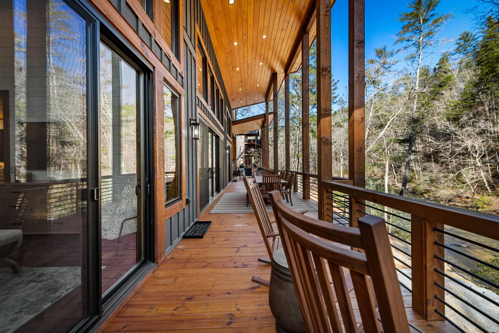 Upper balcony seating area with filtered sunlight and forest views.
